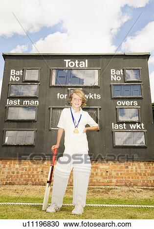 Stock Image - Boy Cricketer with medals and scoreboard. Fotosearch