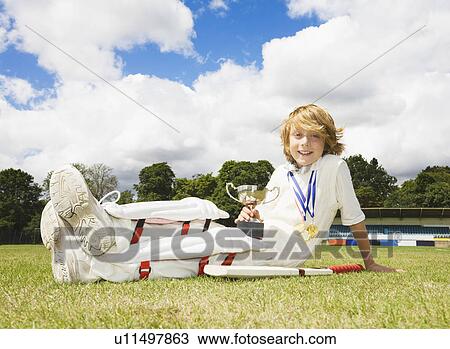 Stock Image - Boy Cricketer with medals and Trophy. Fotosearch