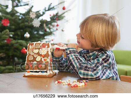 boy decorating gingerbread house View Large Photo Image Stock Photo - boy decorating gingerbread house. Fotosearch