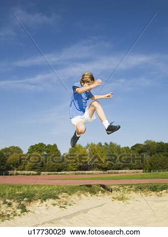 Boy doing the long jump View Large Photo Image Stock Photo - Boy doing the long jump. Fotosearch