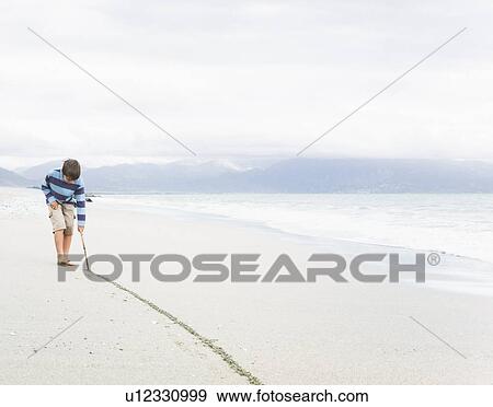 Boy Drawing line in the sand View Large Photo Image Stock Photo - Boy Drawing line in the sand. Fotosearch