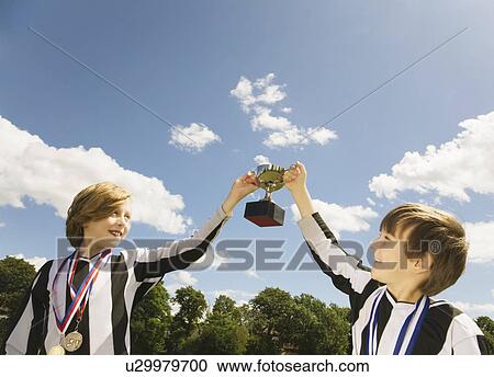 Stock Image - Boy footballers with medals and trophy. Fotosearch