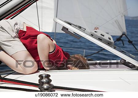Boy looking into hatch on yacht View Large Photo Image Stock Image - Boy looking into hatch on yacht. Fotosearch