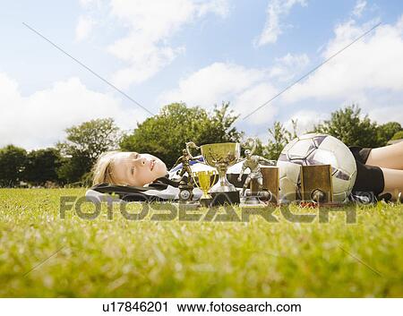 Boy lying on grass with Trophies View Large Photo Image Stock Image - Boy lying on grass with Trophies . Fotosearch