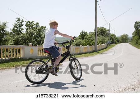 Boy on bicycle on country road View Large Photo Image Stock Image - Boy on bicycle on country road. Fotosearch
