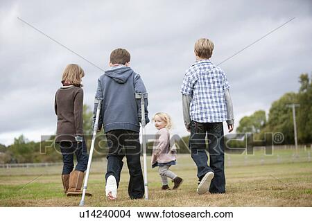Boy on crutches with other children View Large Photo Image Picture - Boy on crutches with other children. Fotosearch