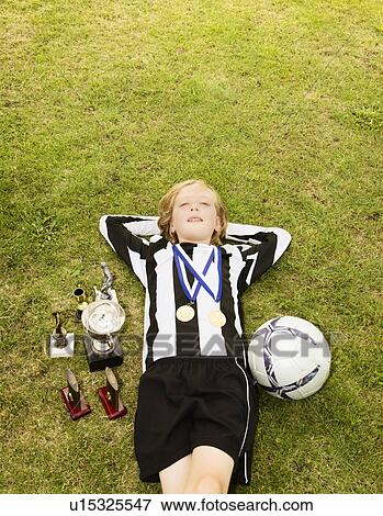 Boy on grass with medals and trophies View Large Photo Image Stock Photo - Boy on grass with medals and trophies. Fotosearch