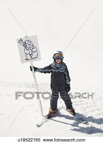 Stock Photography - Boy skier holding snowman sign. Fotosearch