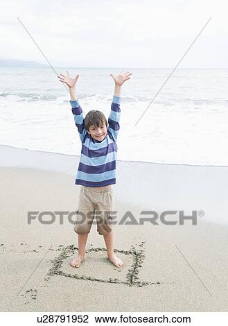 Boy standing in square drawn in sand View Large Photo Image Stock Image - Boy standing in square drawn in sand. Fotosearch