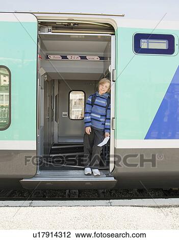 Boy standing on train, holding ticket View Large Photo Image Stock Image - Boy standing on train, holding ticket. Fotosearch
