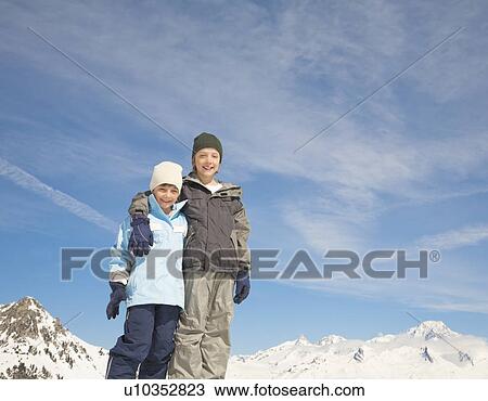 Stock Image - Boys together in snowy mountain scene. Fotosearch
