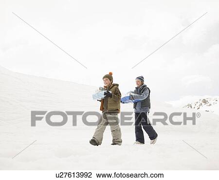 Boys walking with Xmas Presents in snow View Large Photo Image Stock Image - Boys walking with Xmas Presents in snow. Fotosearch