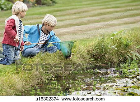 Picture - Brothers with fishing net near pond. Fotosearch