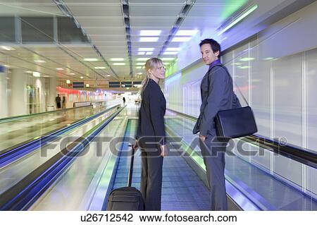 Stock Image - business couple on conveyor belt. Fotosearch