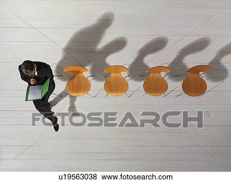 Stock Photo - Business man sitting on chair reading. Fotosearch