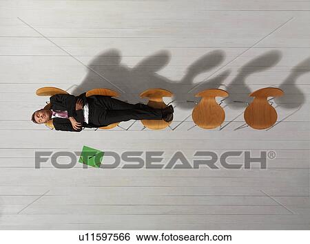 Stock Photograph - Business man sitting on chair reading. Fotosearch