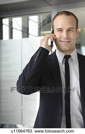 Business man using mobile in office View Large Photo Image Stock Image - Business man using mobile in office. Fotosearch