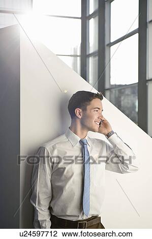 Business man using mobile in office View Large Photo Image Stock Image - Business man using mobile in office. Fotosearch