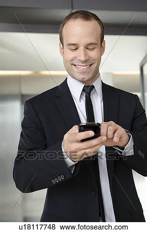Business man using mobile in office View Large Photo Image Stock Photo - Business man using mobile in office. Fotosearch