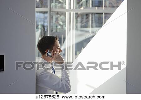 Stock Photography - Business man using mobile in office. Fotosearch