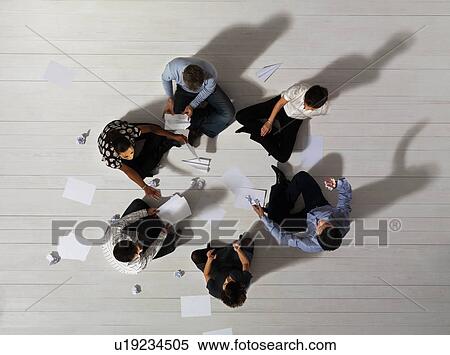 Stock Photography - Business men and women sitting in circle. Fotosearch