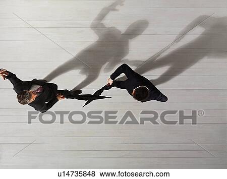Stock Photo - Business men fighting with umbrellas. Fotosearch