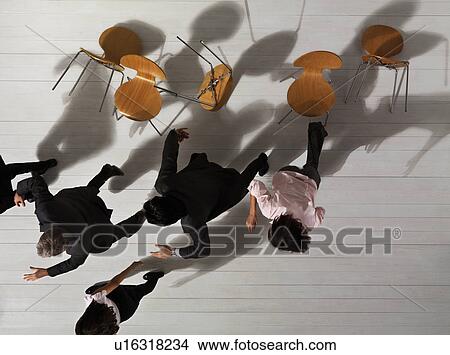 Picture - Business people knocking over chairs. Fotosearch