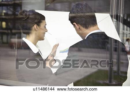 Picture - Business people looking at paperwork. Fotosearch