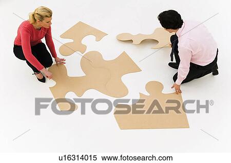 Business people work at finishing puzzle View Large Photo Image Stock Photography - Business people work at finishing puzzle. Fotosearch