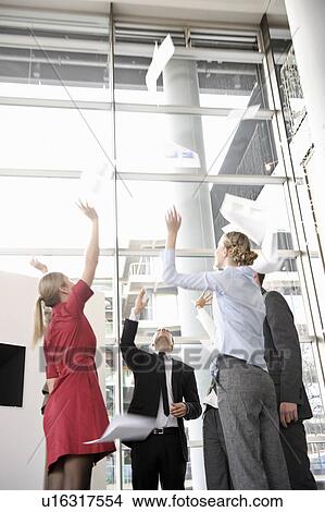 Business team throwing papers in the air View Large Photo Image Picture - Business team throwing papers in the air. Fotosearch