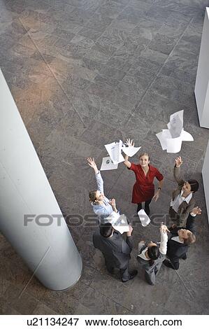 Stock Photo - Business team throwing papers in the air. Fotosearch