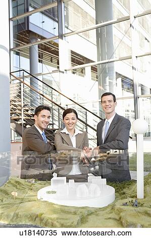 Stock Photography - Business team with architectural model. Fotosearch