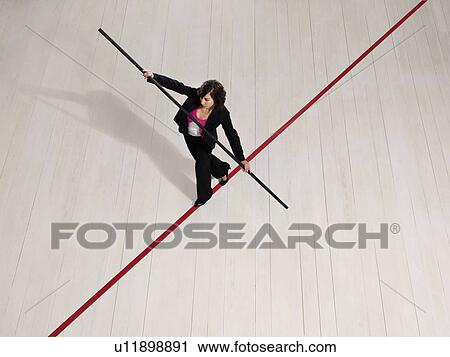 Stock Image - Business woman balancing on red line. Fotosearch