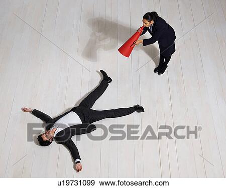 Stock Photo - Business woman shouting at man on floor. Fotosearch