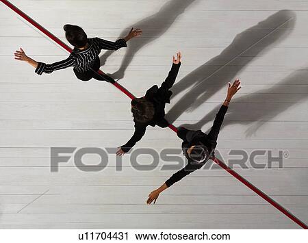 Stock Image - Business women walking along red line. Fotosearch