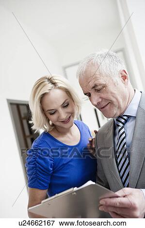 Businessman and woman with clipboard View Large Photo Image Stock Photo - Businessman and woman with clipboard. Fotosearch