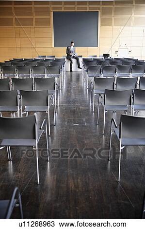 Businessman at head of empty conference View Large Photo Image Stock Image - Businessman at head of empty conference. Fotosearch