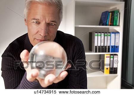 Businessman holding a crystal ball View Large Photo Image Stock Photography - Businessman holding a crystal ball. Fotosearch