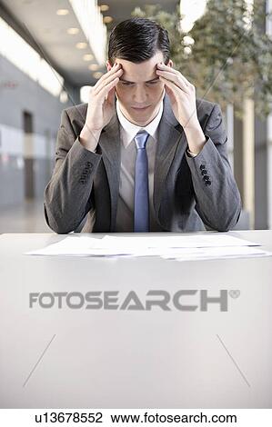 Stock Image - Businessman holding head with hand, port. Fotosearch
