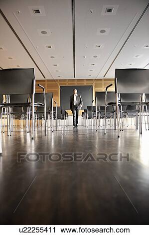 Stock Image - Businessman in empty conference room. Fotosearch