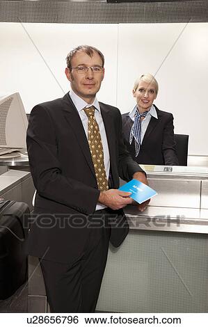 Businessman in front of checkin desk View Large Photo Image Stock Photograph - Businessman in front of checkin desk. Fotosearch
