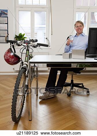 Businessman in office with bicycle View Large Photo Image Stock Photography - Businessman in office with bicycle. Fotosearch