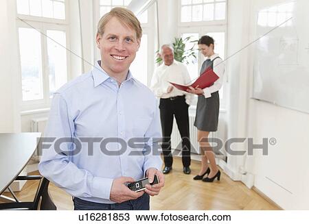 Businessman in office with colleagues View Large Photo Image Stock Image - Businessman in office with colleagues. Fotosearch