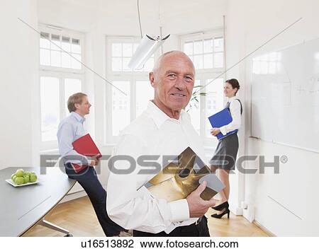 Businessman in office with colleagues View Large Photo Image Stock Image - Businessman in office with colleagues. Fotosearch