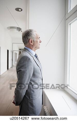 Stock Photo - Businessman looking at window. Fotosearch