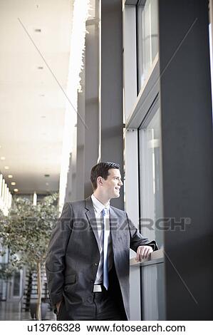 Stock Photo - Businessman looking out office window. Fotosearch
