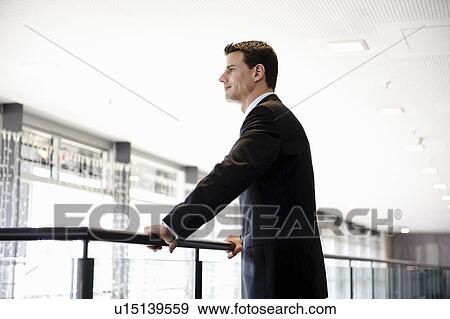 Businessman looking out window View Large Photo Image Stock Photo - Businessman looking out window. Fotosearch