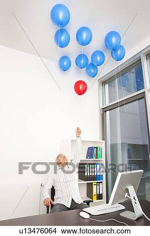 Businessman picking red balloon View Large Photo Image Picture - Businessman picking red balloon. Fotosearch