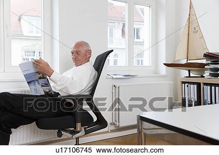 Businessman reading brochure View Large Photo Image Stock Photography - Businessman reading brochure. Fotosearch