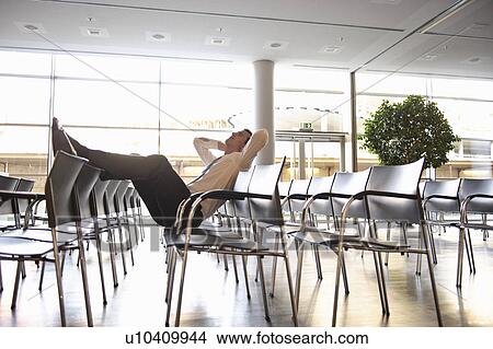 Businessman relaxing in empty conference View Large Photo Image Picture - Businessman relaxing in empty conference. Fotosearch